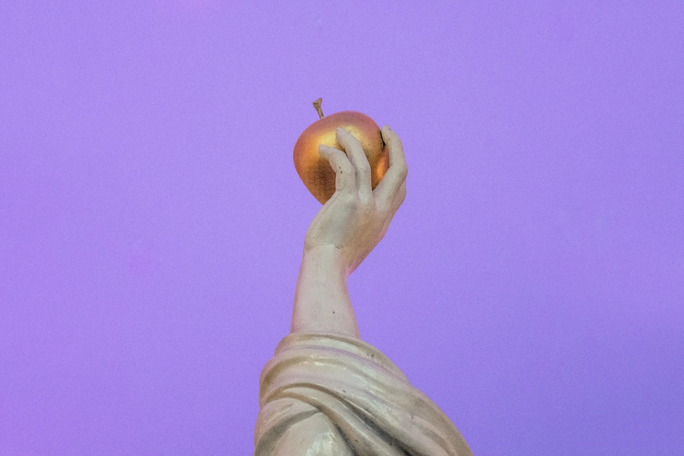 Skulptur mit Apfel in der Hand